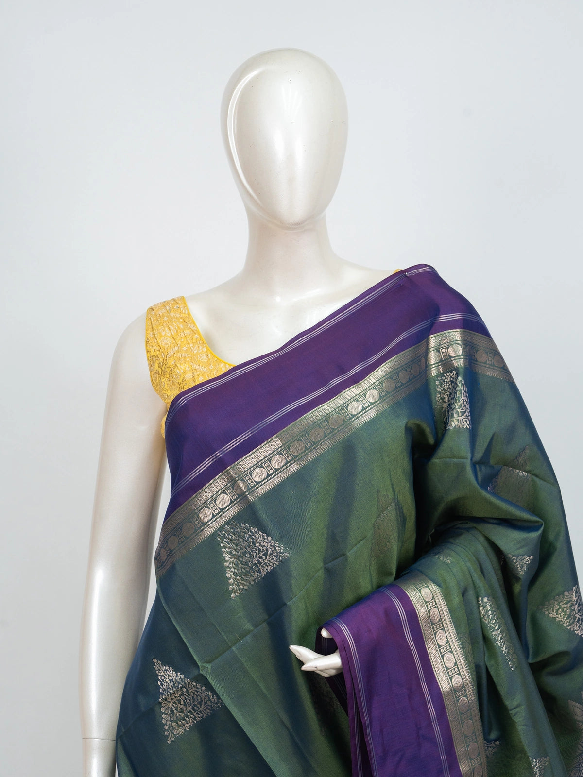 Green Kanchipuram fancy silk saree with contrast purple silver zari border and triangular zari buttas