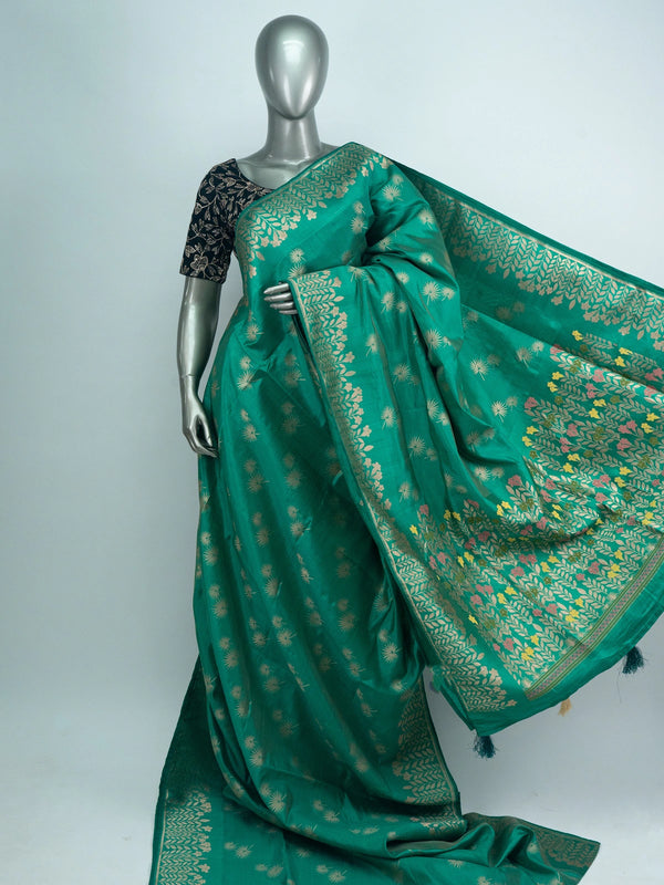Sea green semi raw silk saree with gold zari floral motifs, woven leaf border and a multicolour floral pallu with contrast black blouse