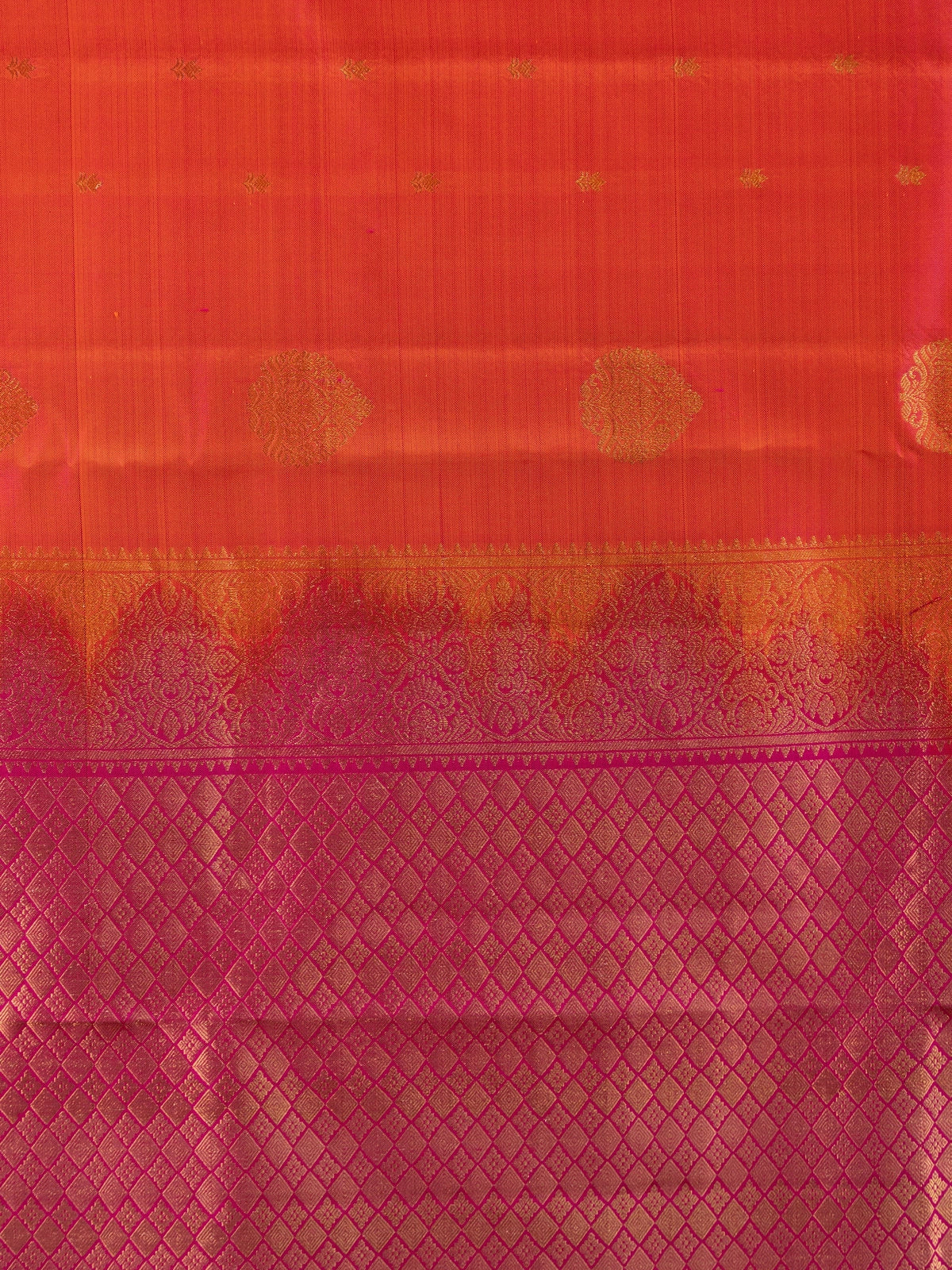Orange pure Kanchipuram silk saree with contrast pink zari border and gold buttas