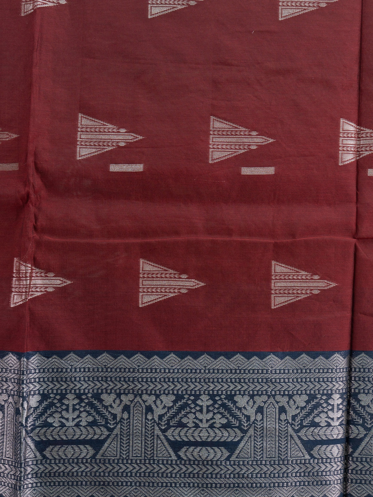Maroon silk cotton saree with silver zari triangular motifs and contrast navy blue zari border and pallu