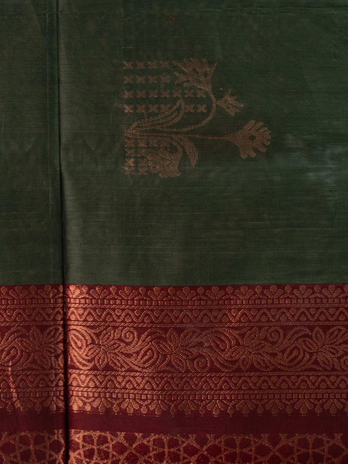Dark green silk cotton saree with copper zari buttas and contrast maroon border and pallu