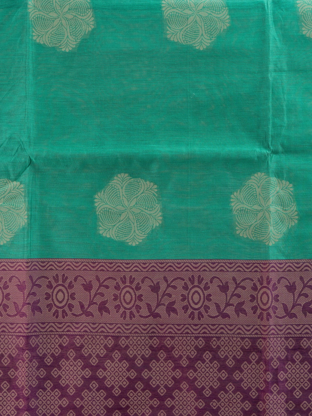 Teal green silk cotton saree with cream floral buttas and contrast purple woven border and pallu