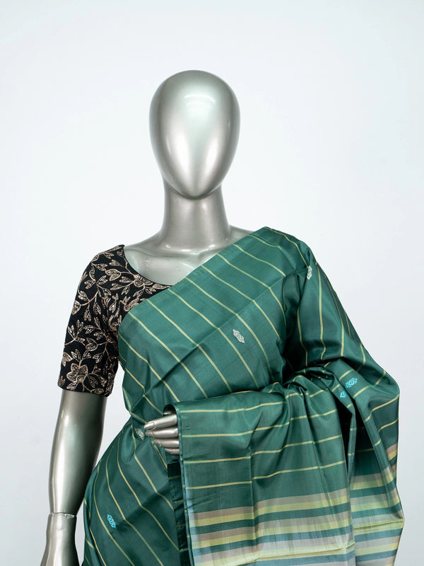 Bottle green banana silk saree with gold zari stripes, woven buti motifs and a contrast silver-grey tasselled pallu
