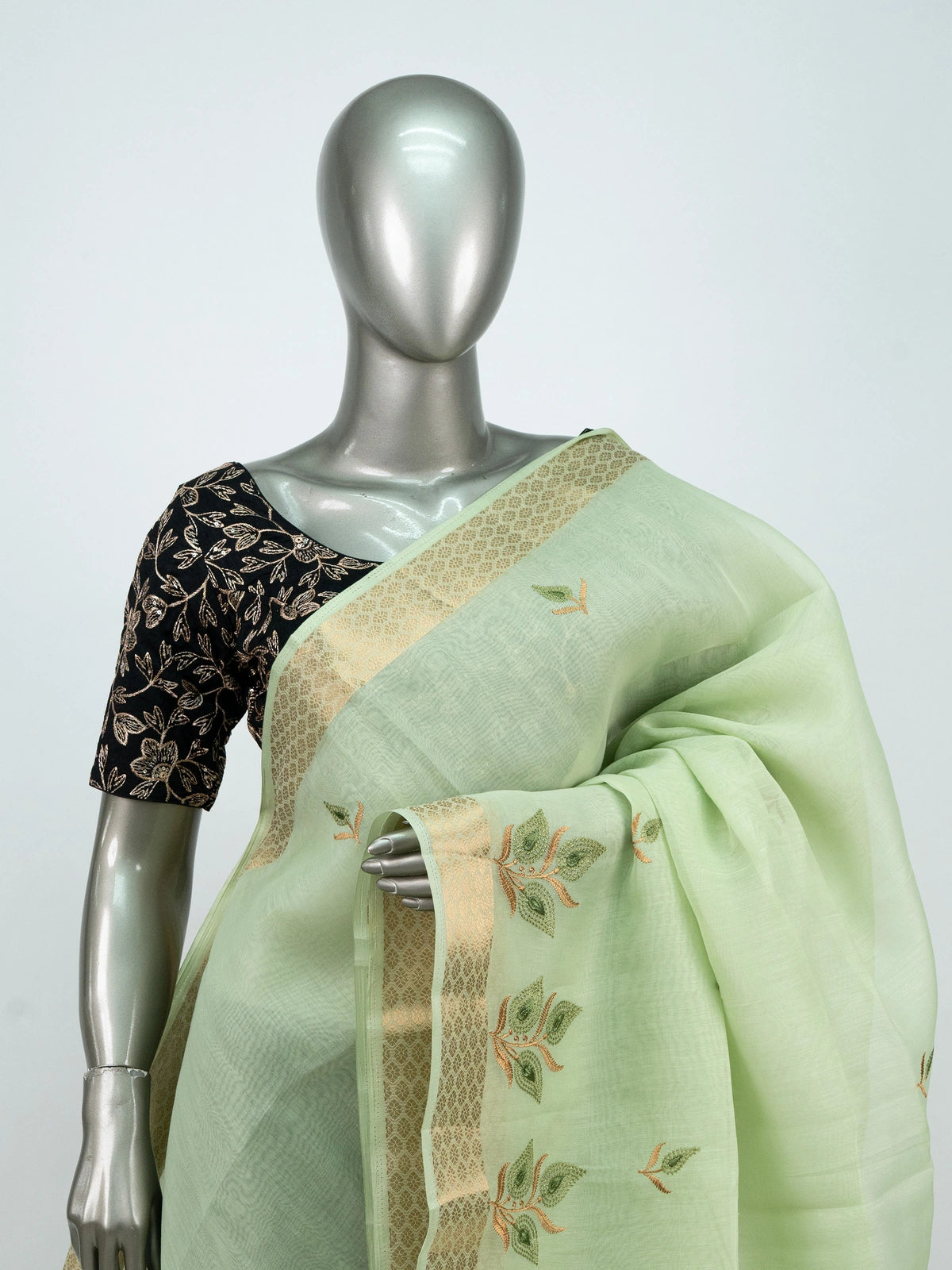 Pista green linen cotton saree with gold zari border, embroidered leaf buttas and contrast black embroidered blouse