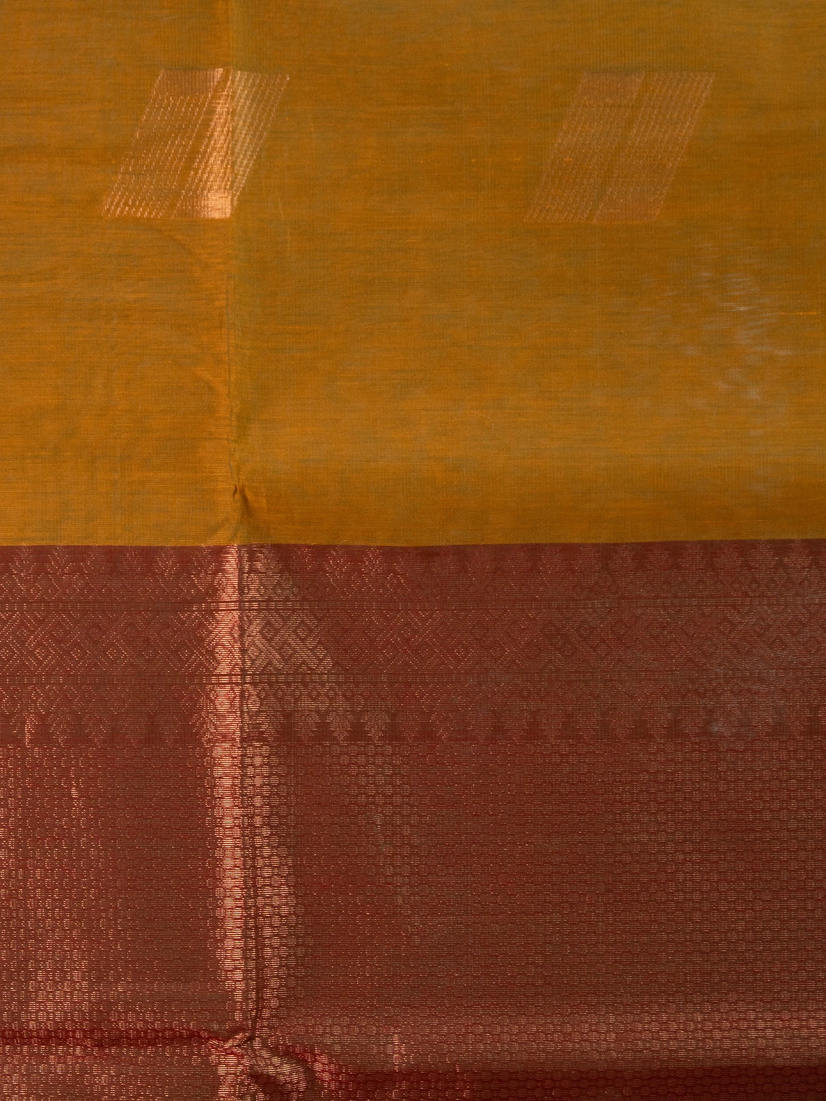 Mustard silk cotton saree with orange border, zari buttas, and a maroon copper-zari pallu