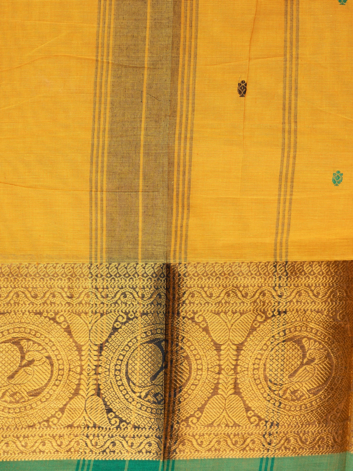 Mustard yellow Chettinad cotton saree with green contrast border, gold zari peacock motifs and woven buttis