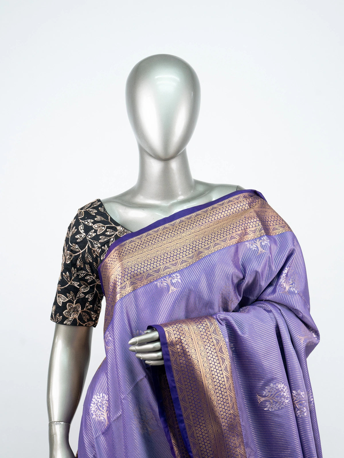Lavender soft silk saree with gold zari tree motifs, navy blue pallu and black embroidered blouse