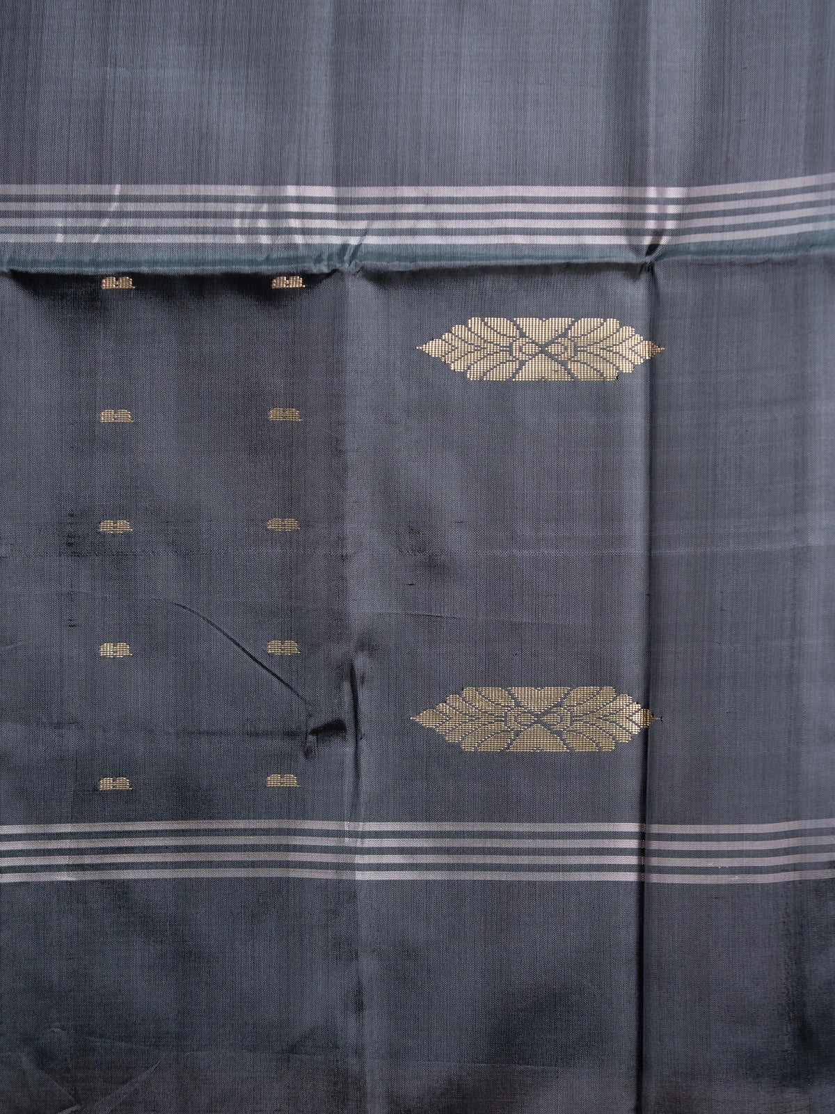 Blush beige Banana Silk saree with charcoal grey contrast pallu, gold zari leaf motifs and blue butta work
