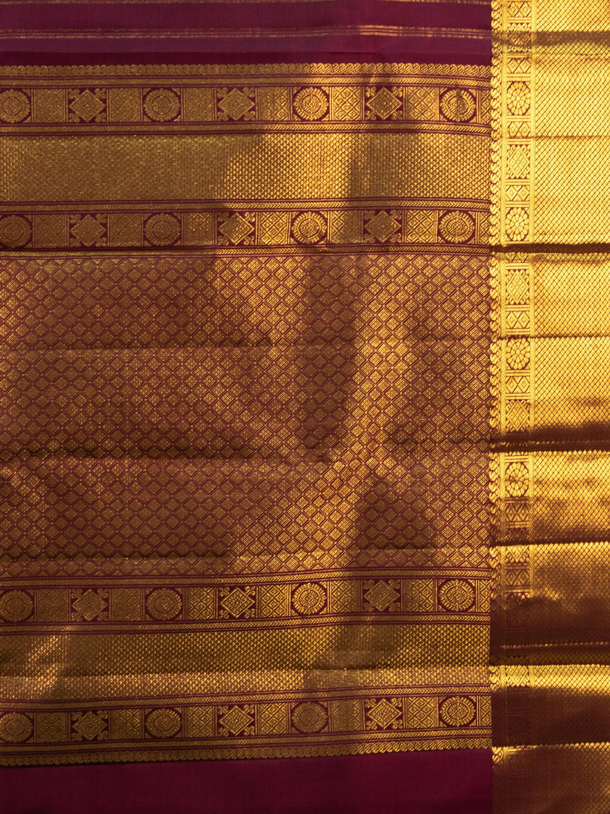 Maroon pure Kanchipuram silk saree with gold zari border, buttas and ornate woven pallu