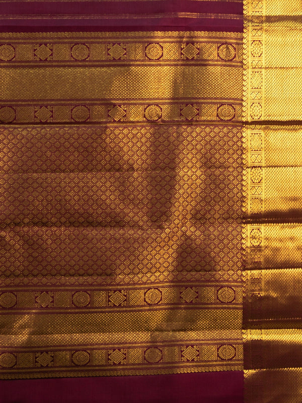 Maroon pure Kanchipuram silk saree with gold zari border, buttas and ornate woven pallu