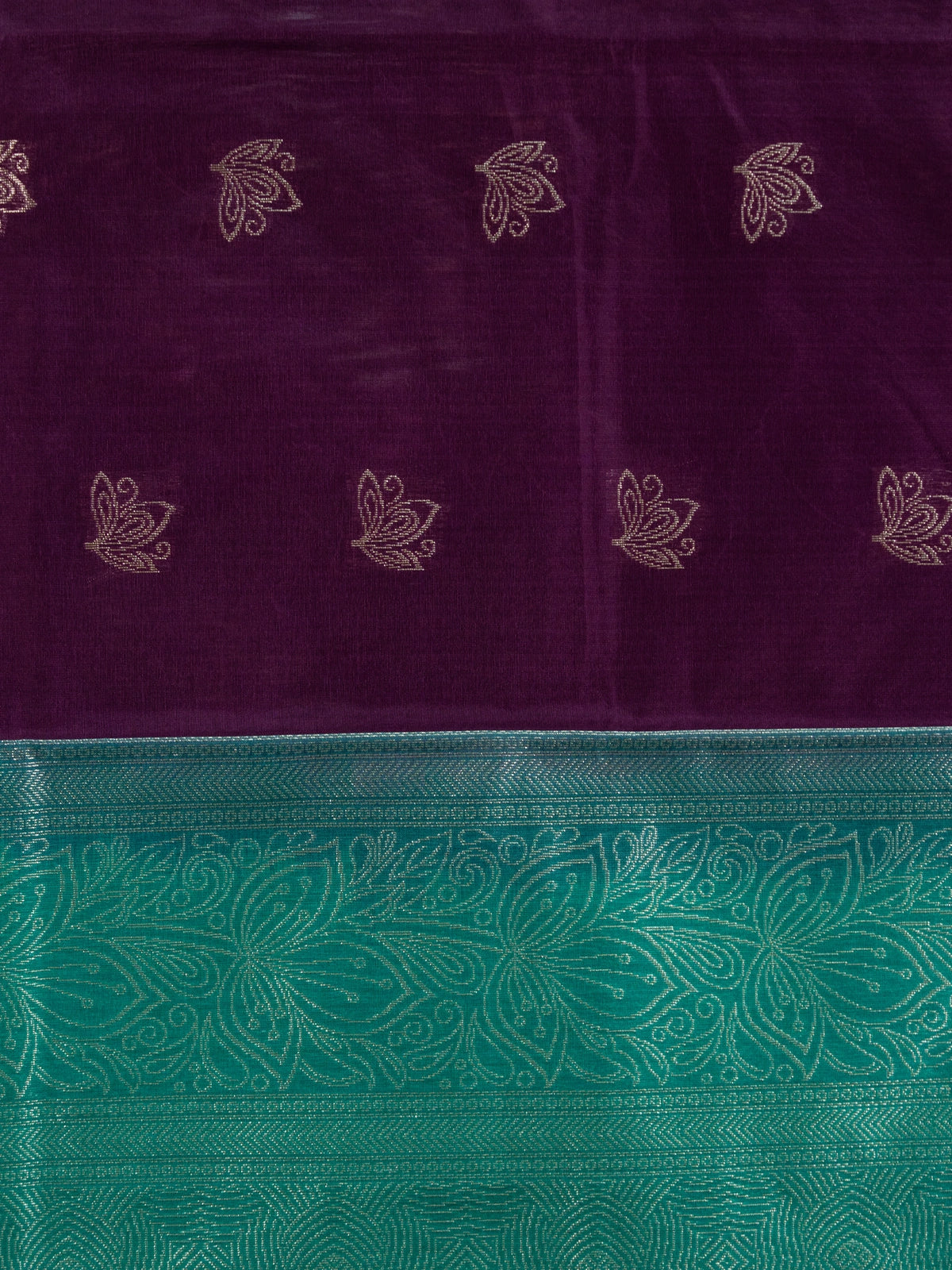 Purple silk cotton saree with teal-green contrast border and gold zari lotus motifs