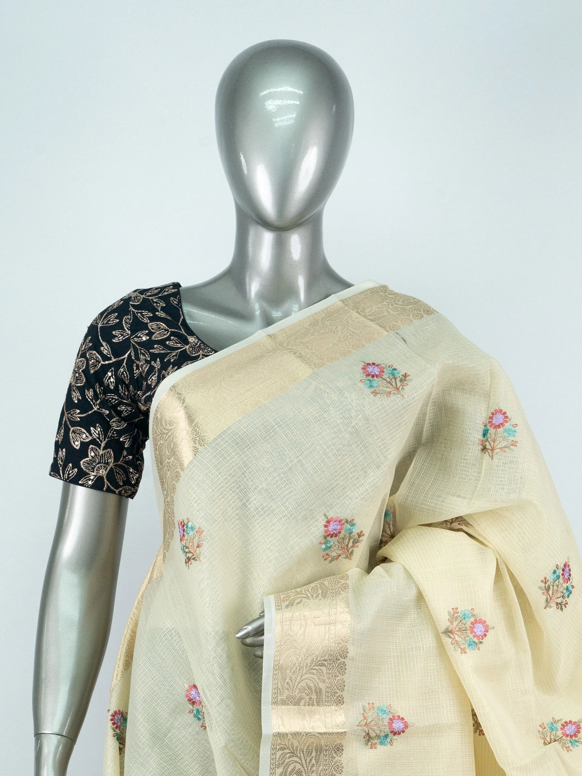 Cream linen cotton saree with gold zari border and multicoloured floral embroidered butas