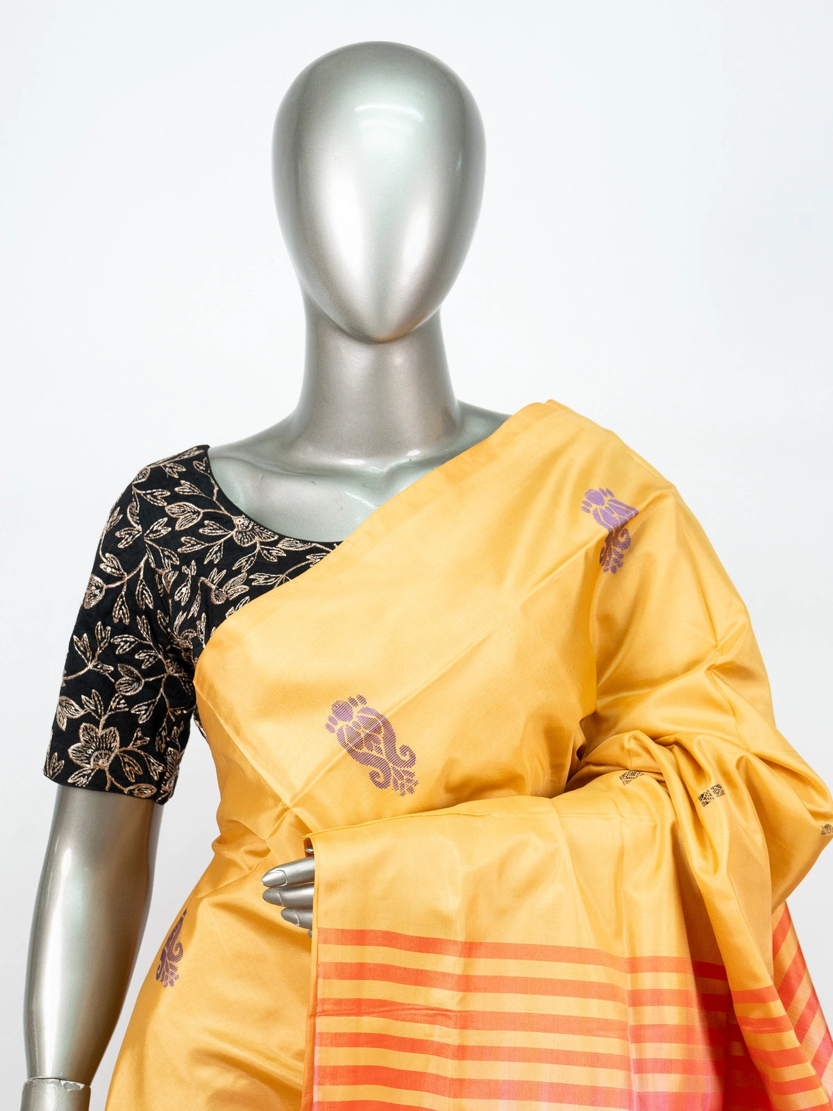 Mustard yellow banana silk saree with contrast pink pallu, purple paisley butis and gold zari work