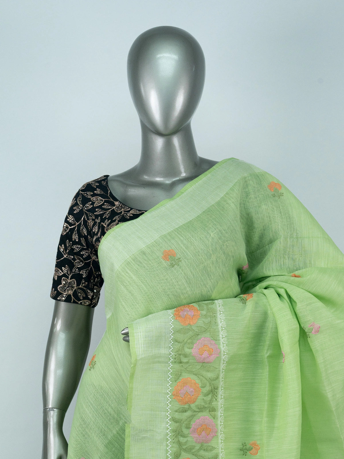 Light green linen cotton saree with silver zari border and multicoloured floral embroidery