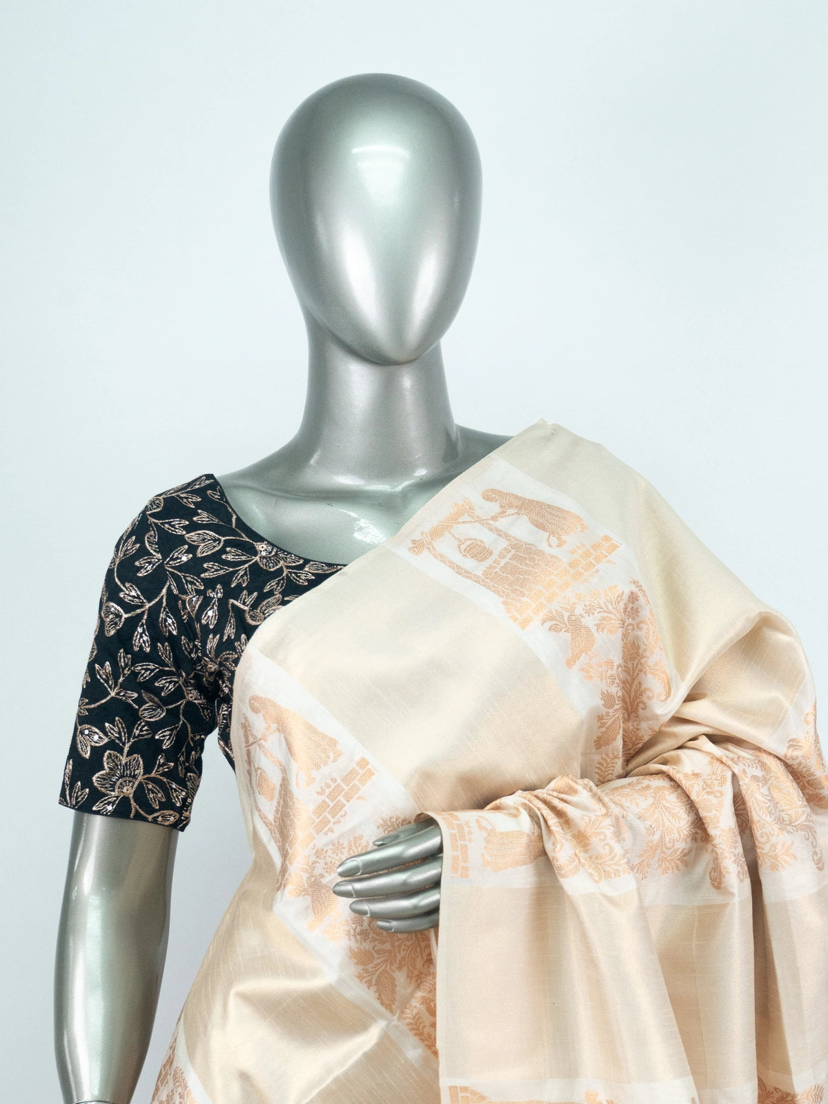 Cream semi raw silk saree with copper woven paisley and floral motifs and a contrasting embroidered black blouse