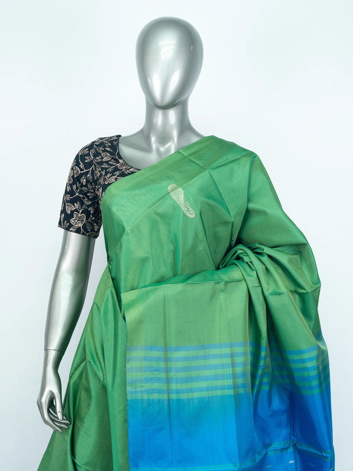 Green banana silk saree with contrast blue pallu, silver paisley motifs and striped border