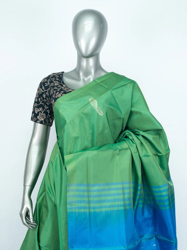 Green banana silk saree with contrast blue pallu, silver paisley motifs and striped border