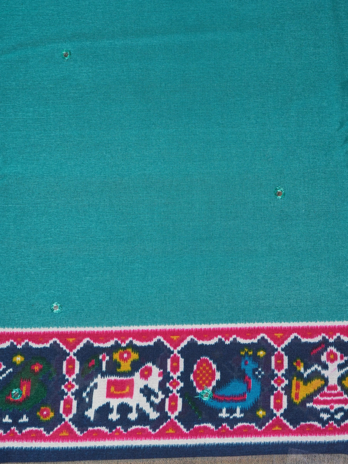 Teal linen cotton saree with navy and pink patola-style border, peacock and elephant motifs, and contrast blouse