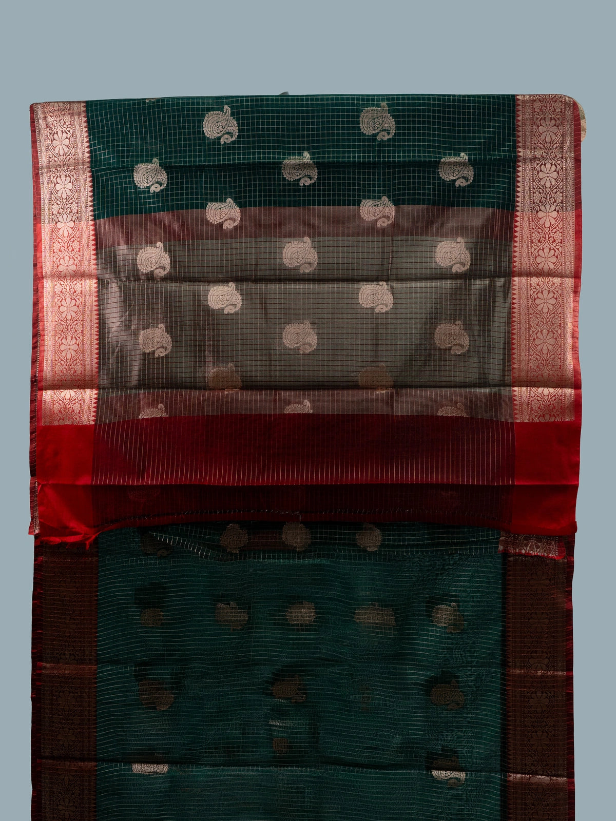 Dark green semi raw silk saree with red contrast zari border and paisley butta motifs