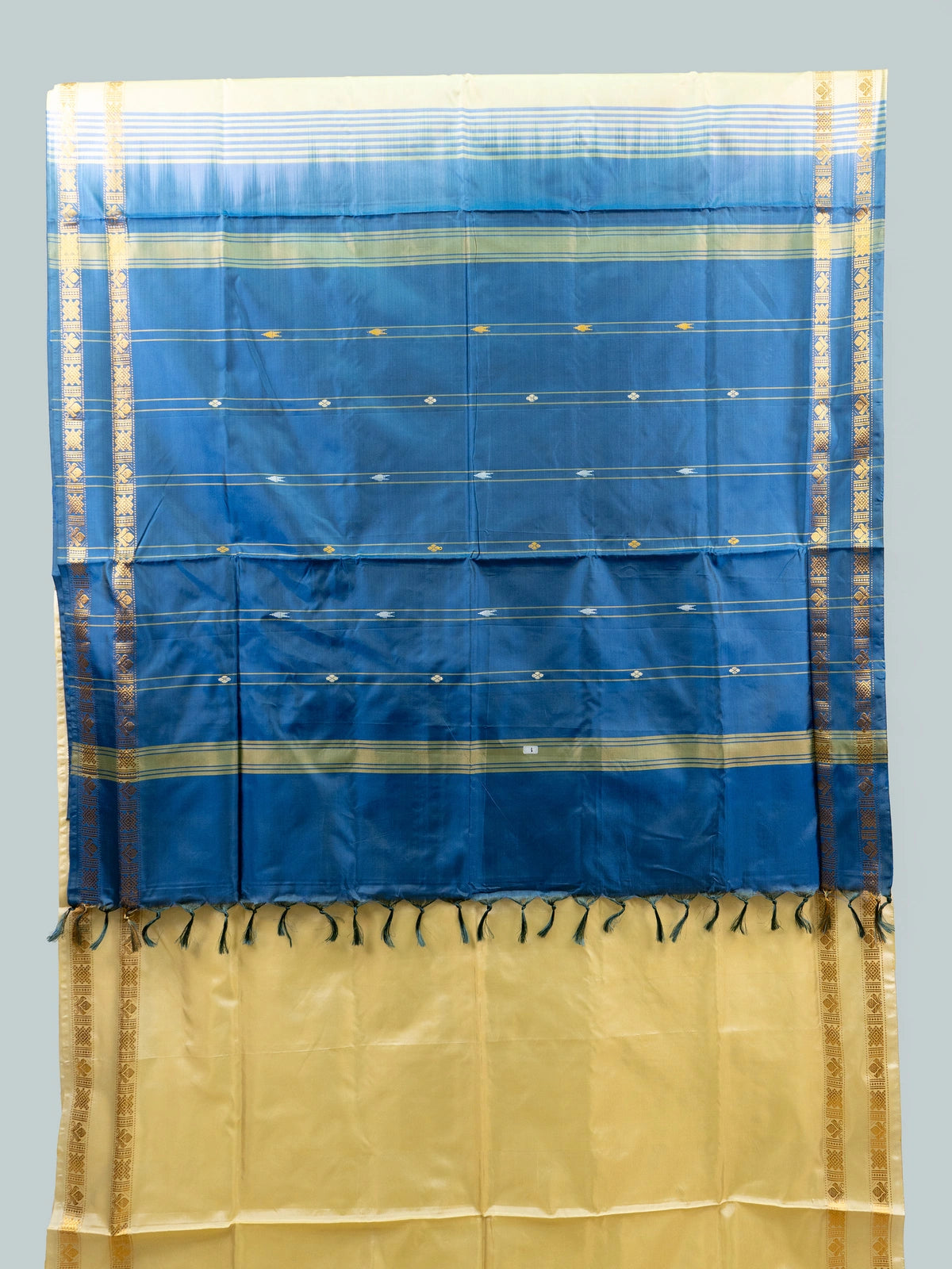 Cream and blue banana silk saree with gold zari border and contrast blue pallu
