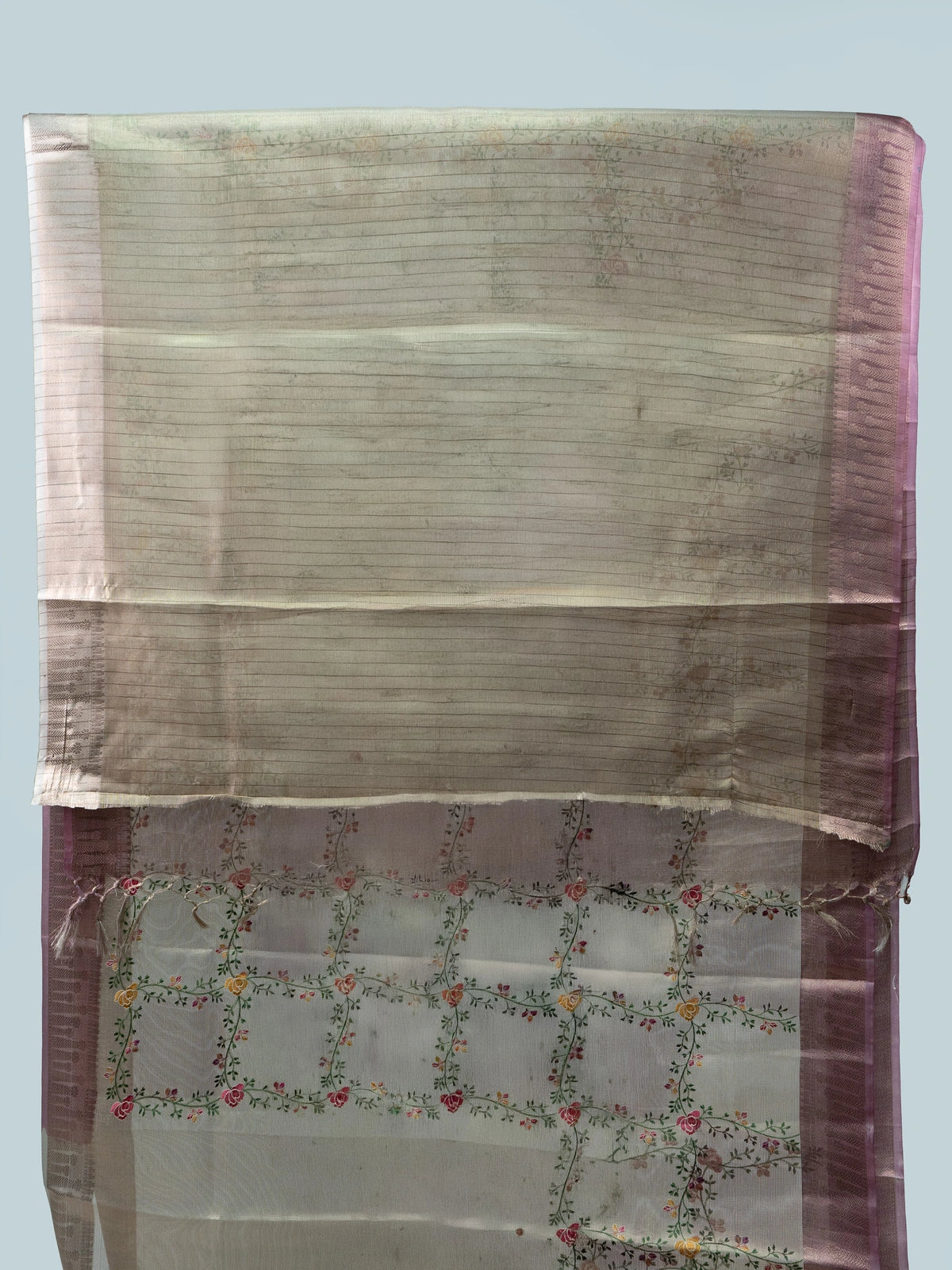 Beige linen cotton saree with mauve pink zari border, multicoloured floral embroidery and a black contrast blouse