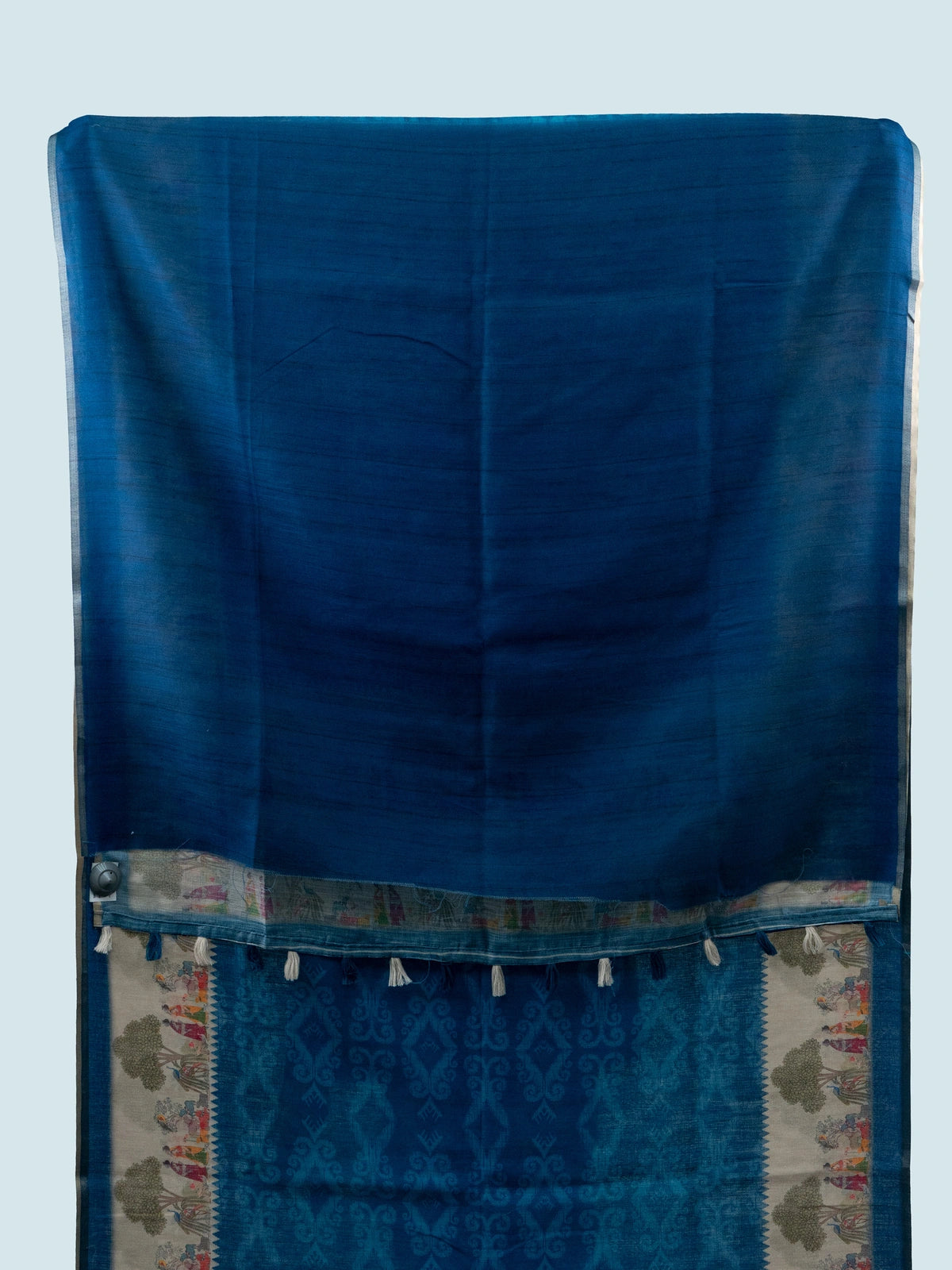 Peacock blue linen cotton saree with cream folk-art border and pallu featuring trees, figures and peacocks