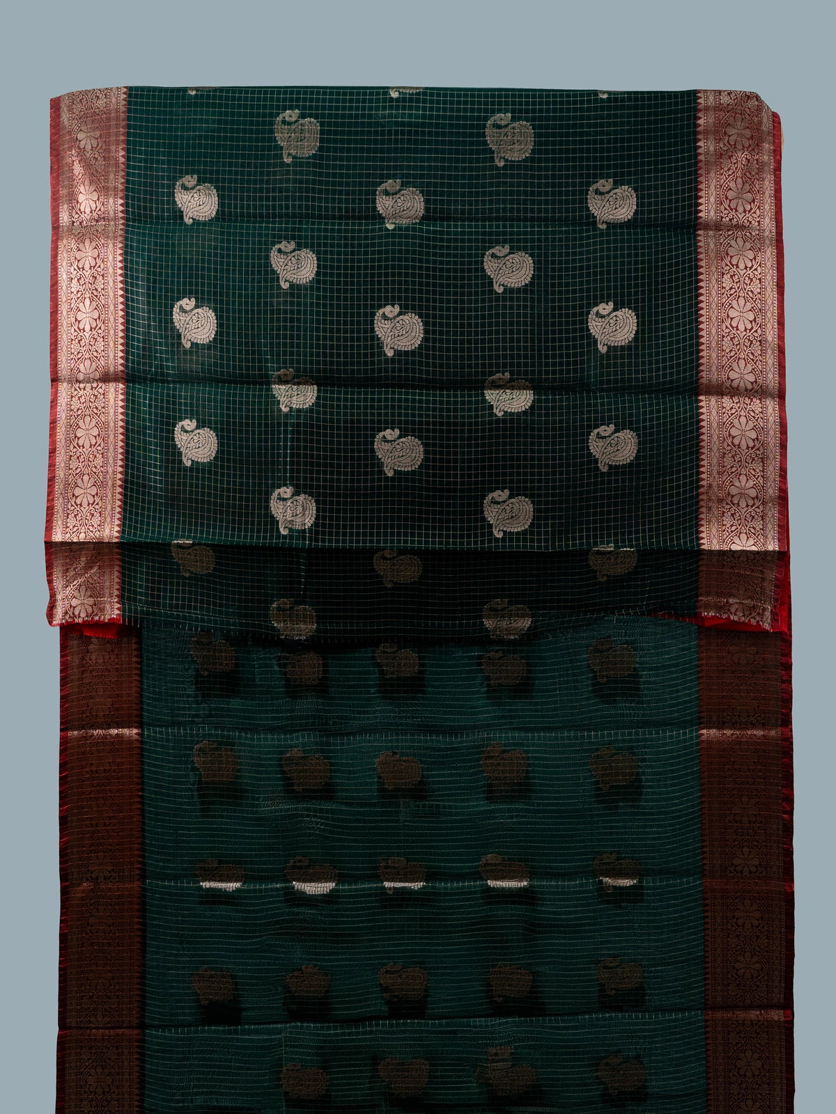Dark green semi raw silk saree with red contrast zari border and paisley butta motifs