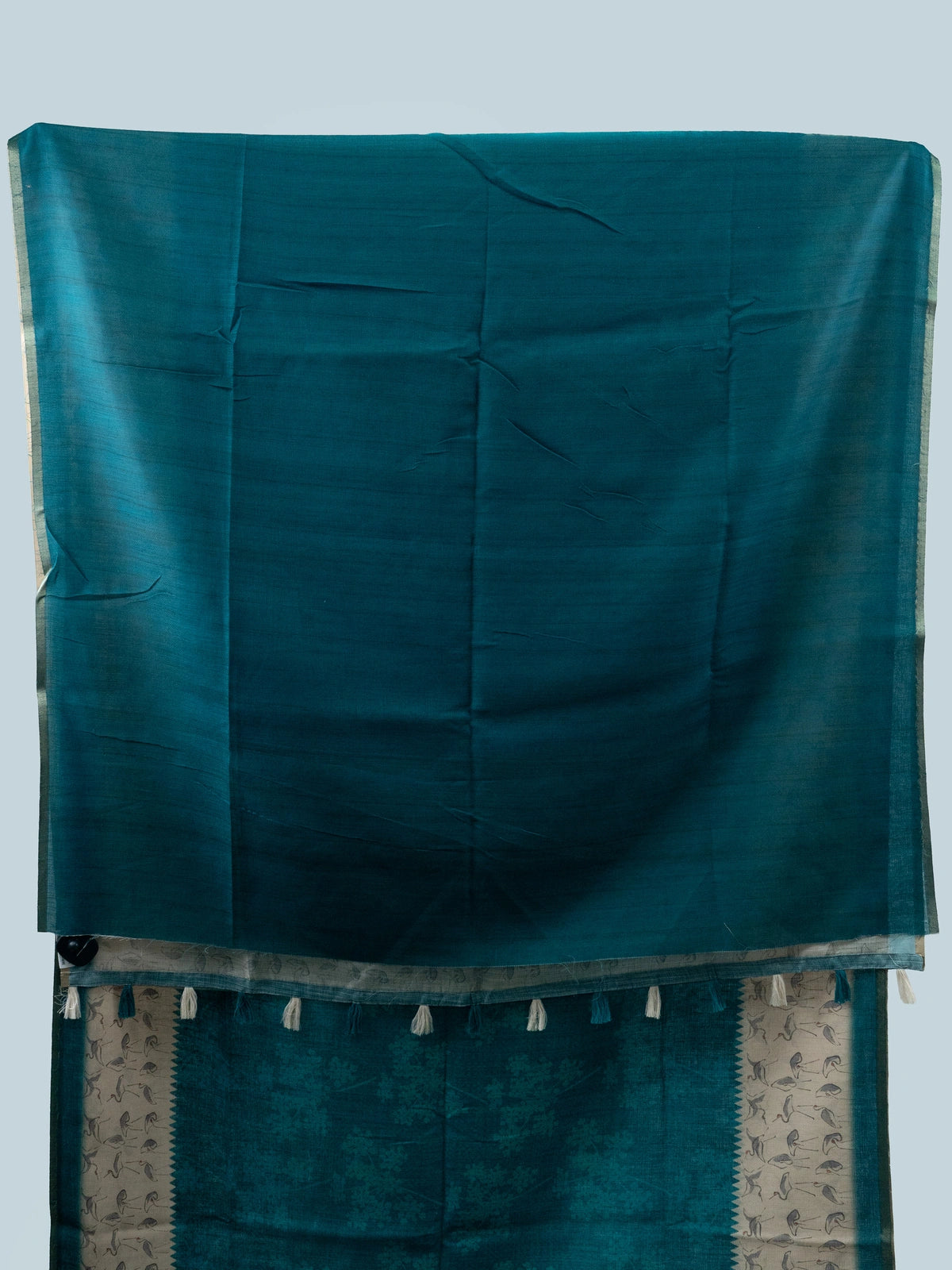 Teal linen cotton saree with cream crane-motif contrast border and temple-style edging