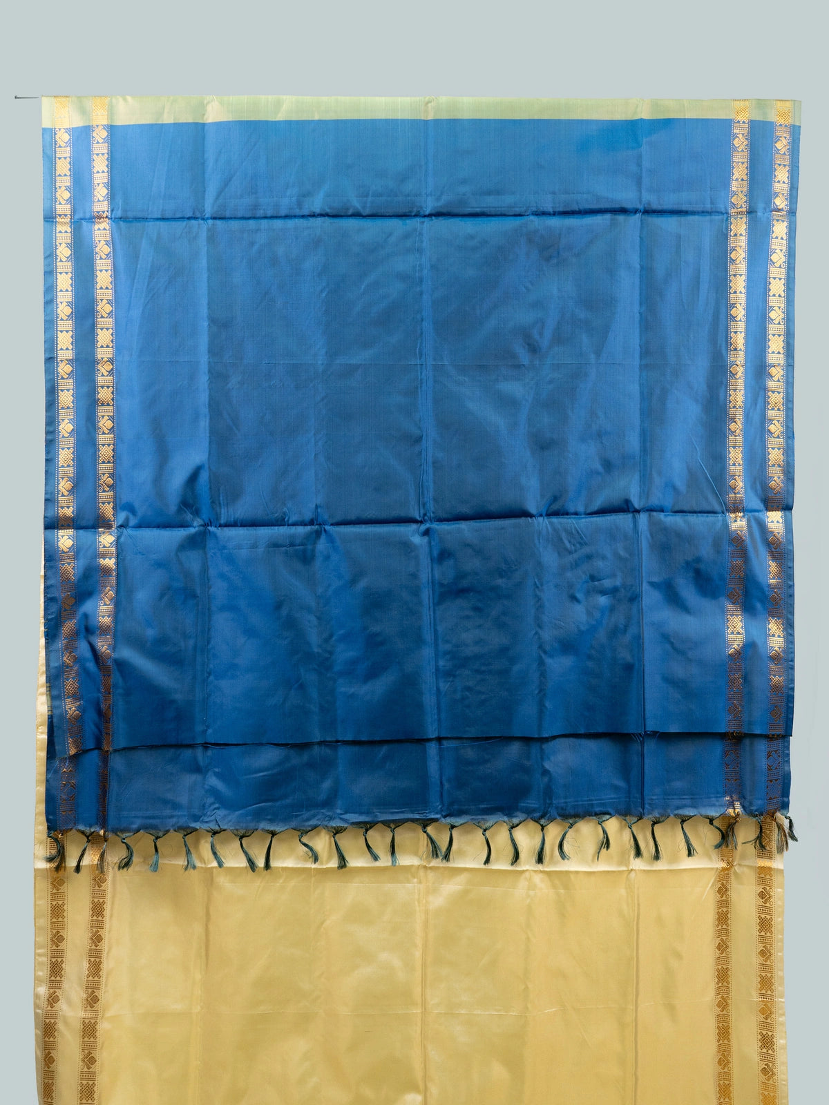 Cream and blue banana silk saree with gold zari border and contrast blue pallu