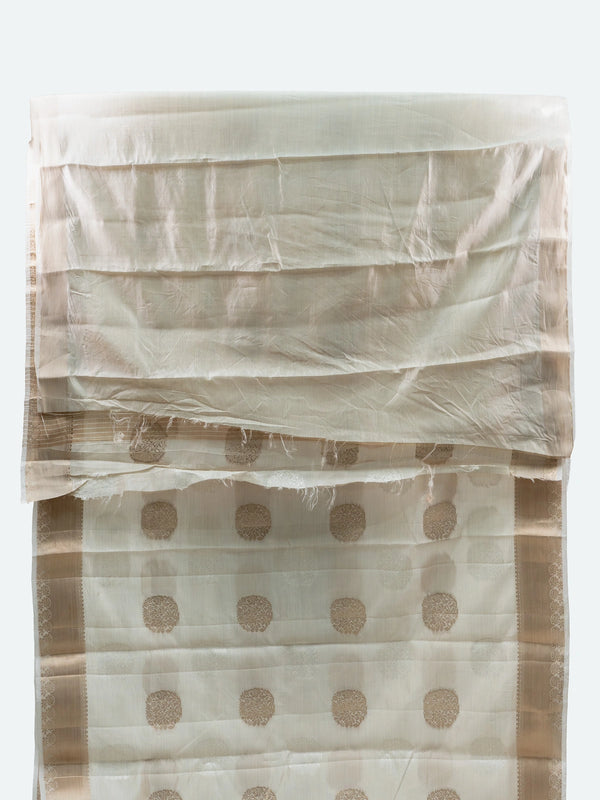 Cream semi raw silk saree with gold zari buttas, gold zari border and contrast black embroidered blouse
