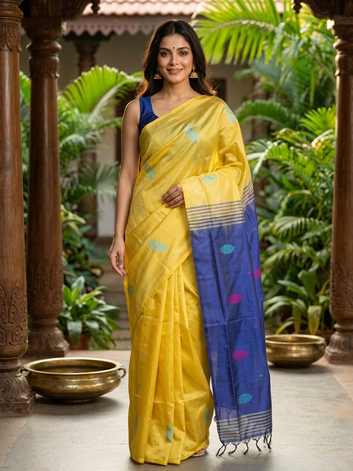 Yellow banana silk saree with navy blue contrast pallu, turquoise buttas and gold zari striped border