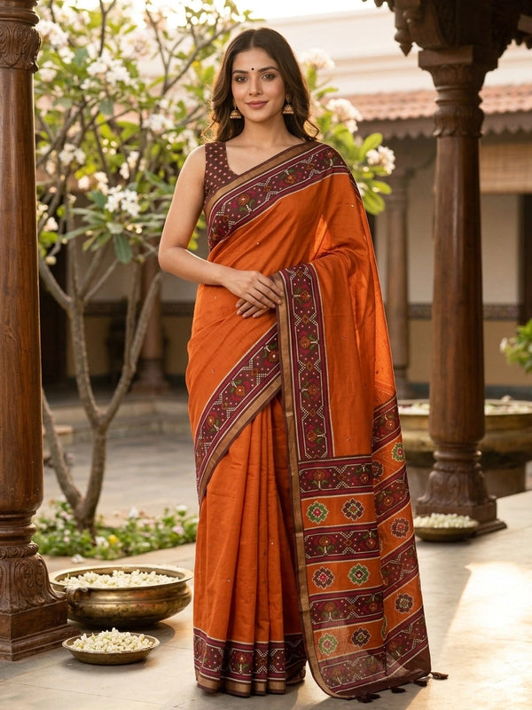 Rust orange linen cotton saree with patola-print brown border, mirror-work buttis and contrast blouse