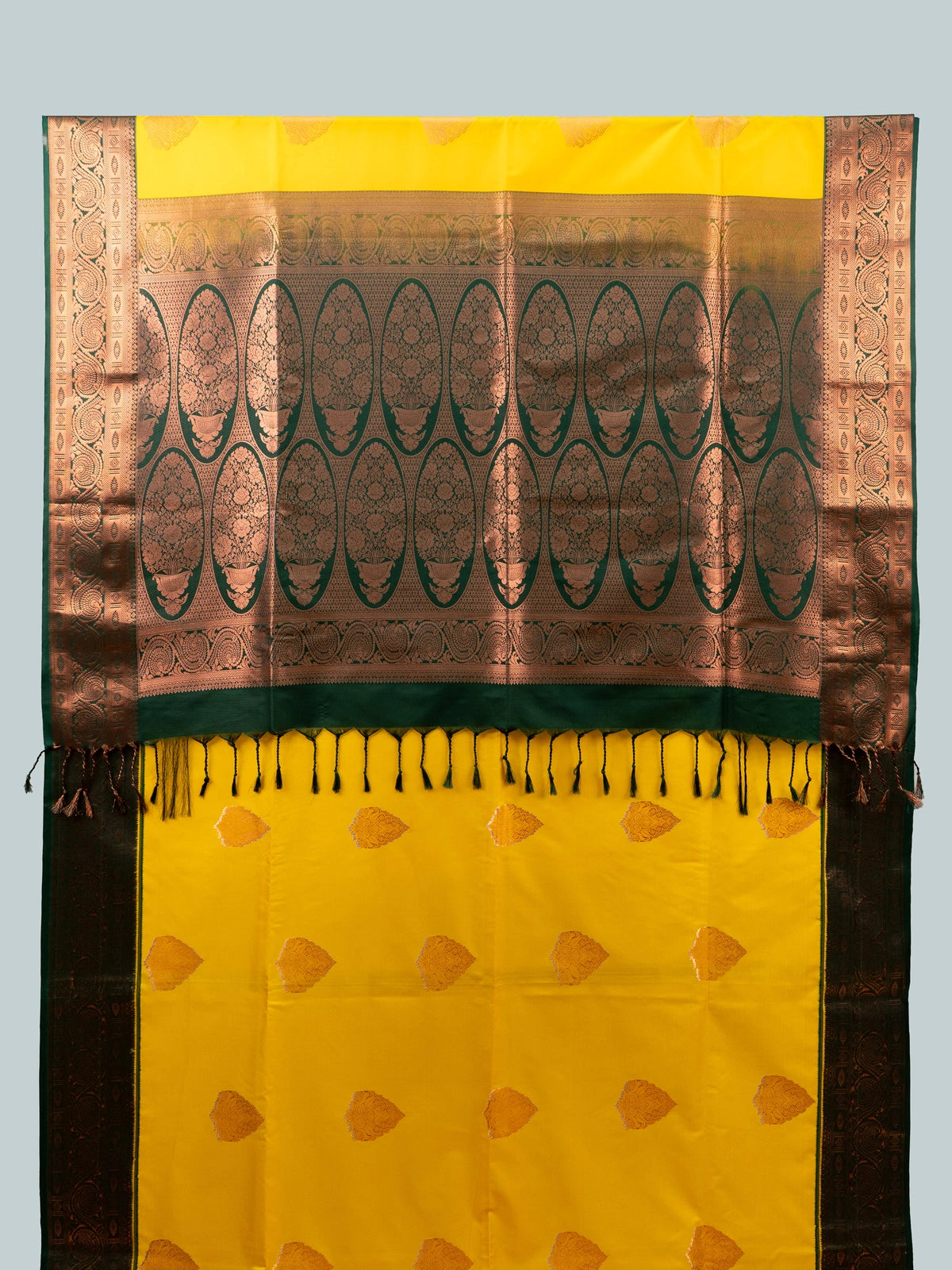 Yellow semi silk saree with dark green contrast border, copper zari buttas and black floral blouse