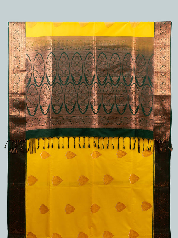 Yellow semi silk saree with dark green contrast border, copper zari buttas and black floral blouse