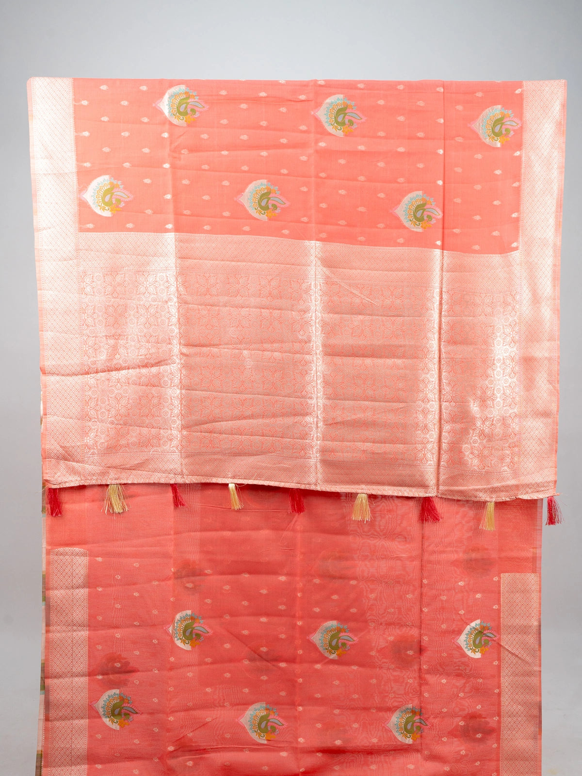 Peach linen cotton saree with silver zari border, peacock motifs and floral zari pallu