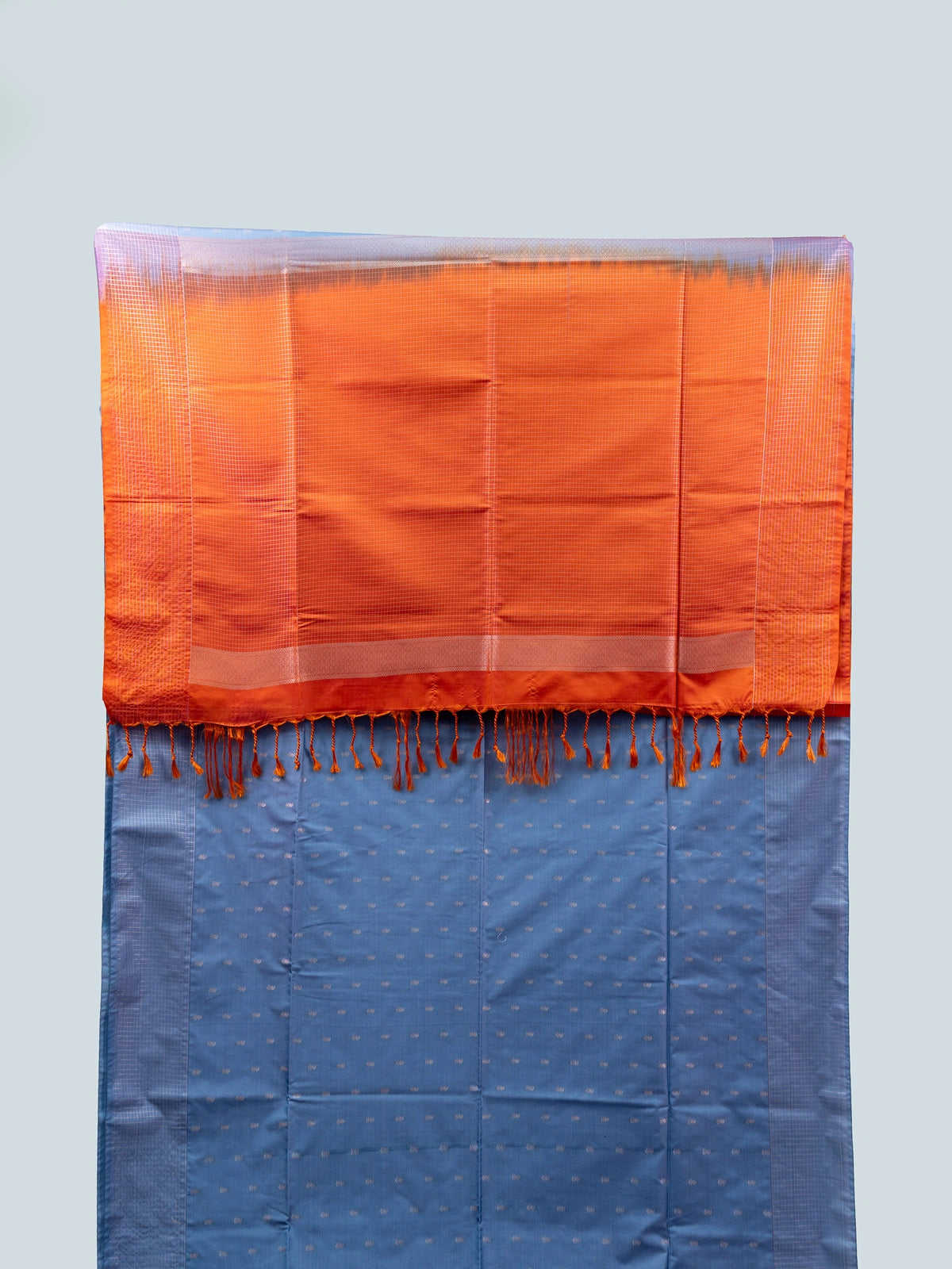 Dusty blue-grey Vaira Oosi Design semi silk saree with silver zari buttis and contrast orange zari pallu and border