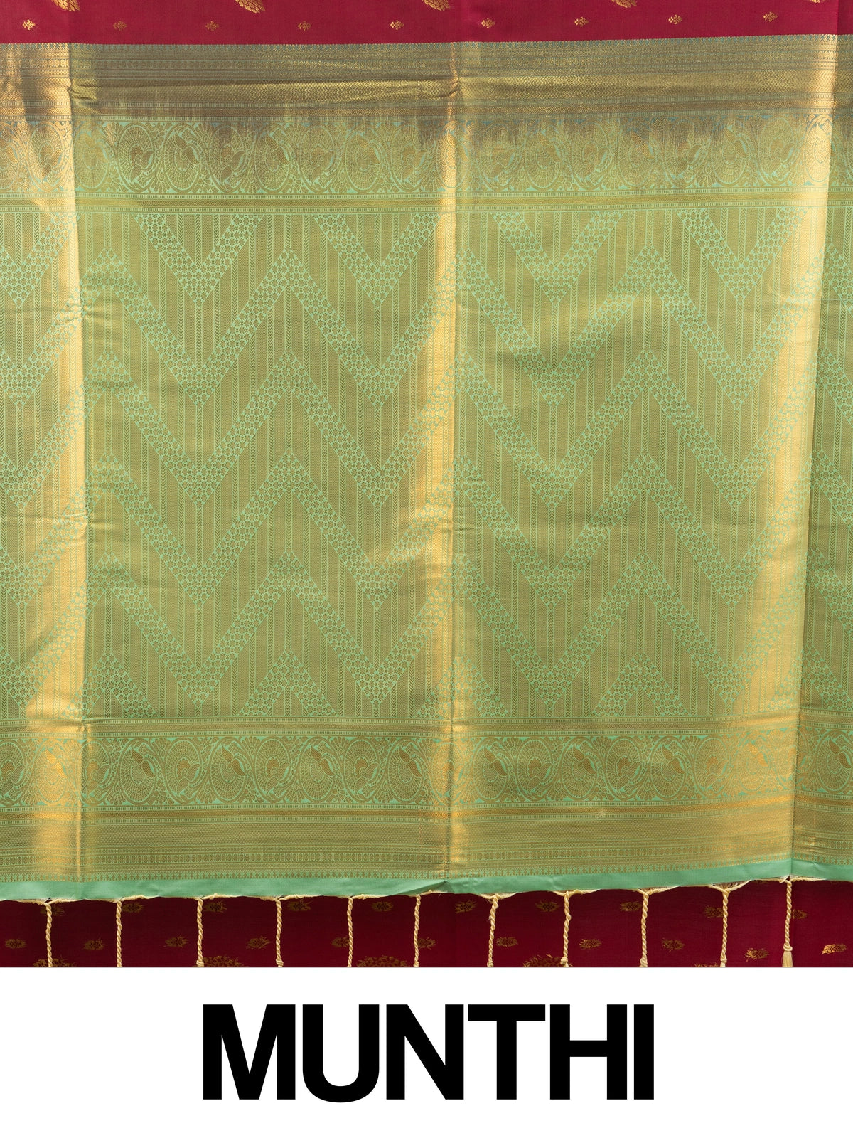 Maroon Kanchipuram fancy silk saree with contrast green and gold zari border and floral zari buttis