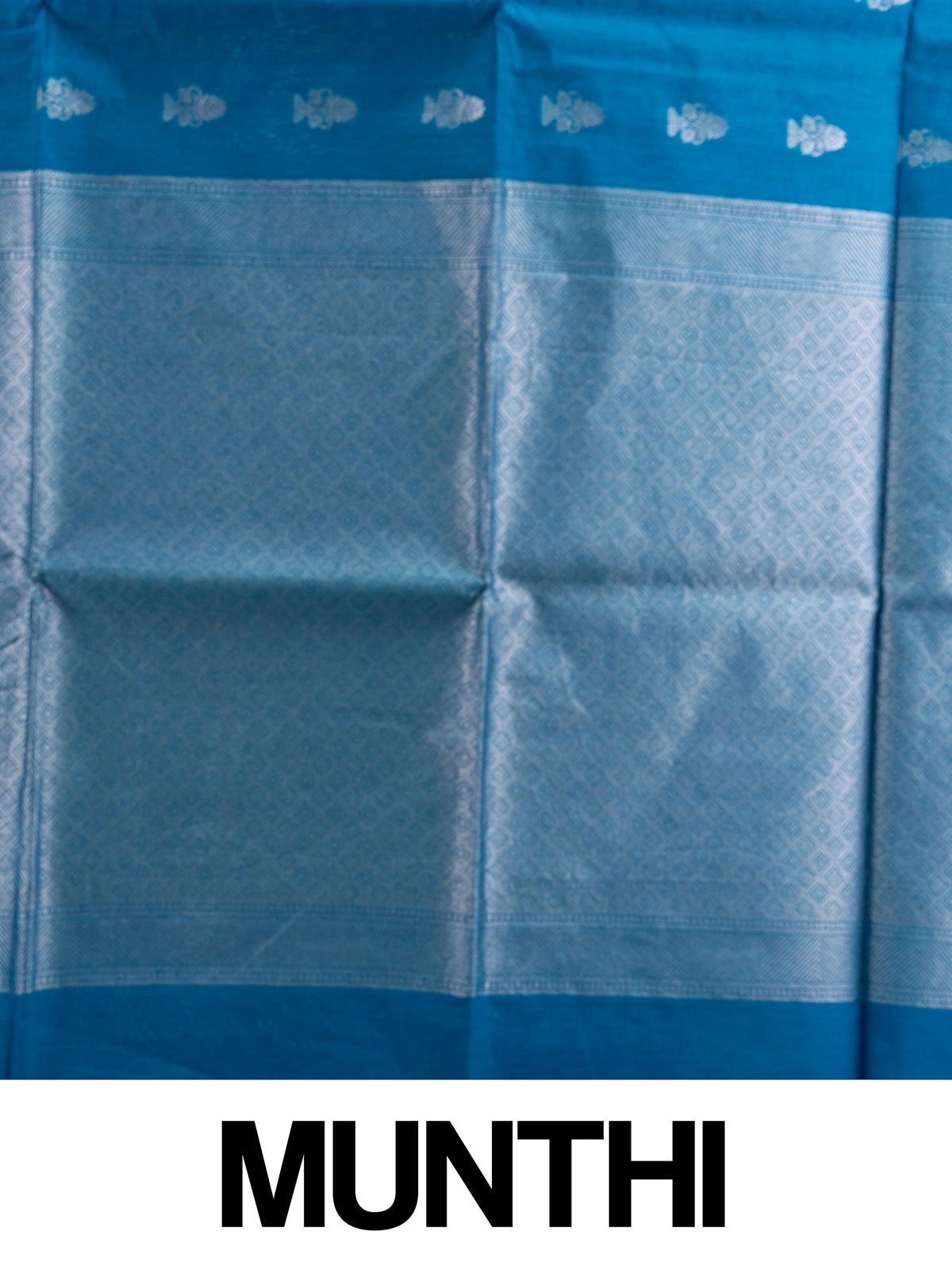 Peacock blue silk cotton saree with silver zari floral buttas and diamond-patterned border
